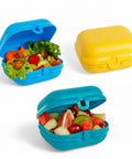 Banana 600ml food-grade PP plastic lunch box with hinged lid, shown in blue and yellow, filled with salad or fruit.
لانش بوكس سناكس و خضروات و فاكهه