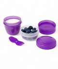BananaHere 500ml snack container with two purple cups, one filled with yogurt, one with blueberries, and a purple spork.
شوكه و معلقه ، علبه سناكس ، كب زبادى