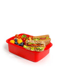 Banana 1.5L red lunch box with removable splitter filled with sandwiches, blueberries, and cherry tomatoes.