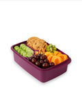 Banana 1.5L purple lunch box with removable splitter filled with cookies, grapes, cucumber slices, apricots, kiwi, and nuts.