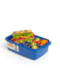 Banana 1.5L blue lunch box with removable splitter, filled with a sandwich, blueberries, kiwi, cherry tomatoes, cucumber, and carrots.