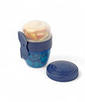 Banana 500ml snack cup with blue textured grip, transparent lid, and attached blue fork-spoon utensil. Filled with apple slices.
شوكه و معلقه ، علبه سناكس ، كب زبادى